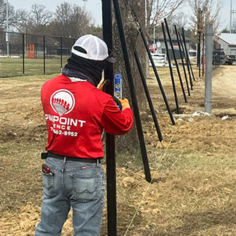 Pinpoint Fence Contractor Standing in front of a vinyl fence